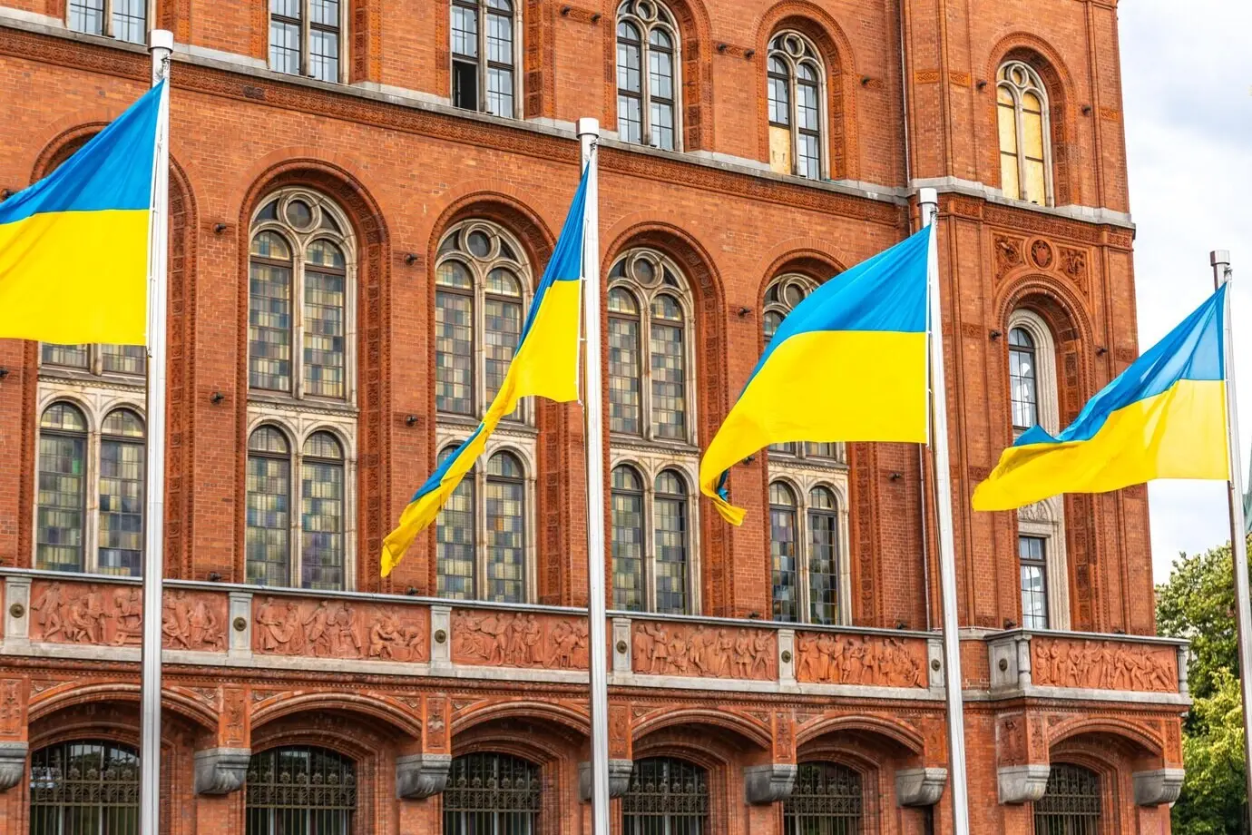 Ukrainische Flaggen wehen vor alter Architektur – ein Symbol für Einheit und nationalen Stolz.
